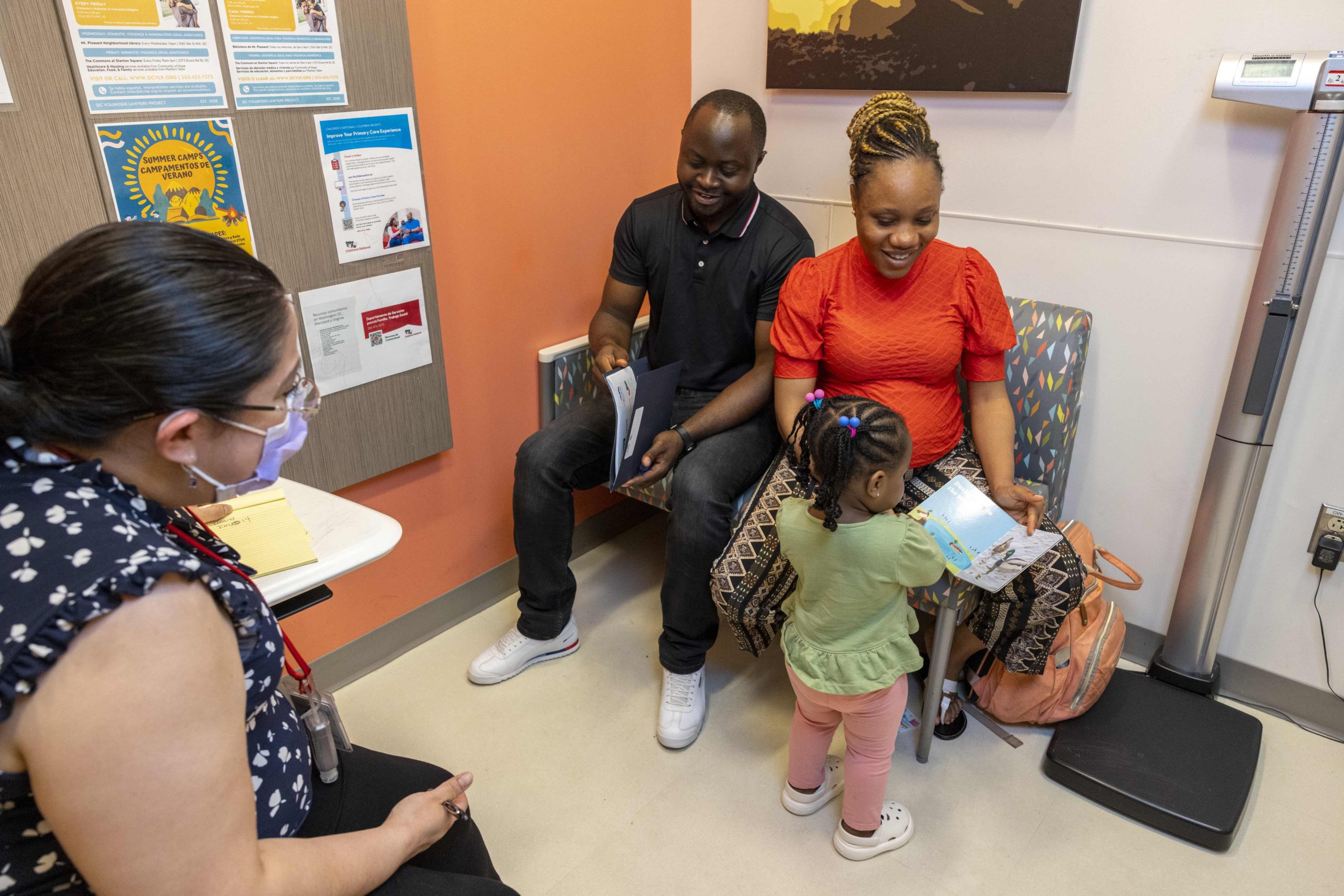 Parents and child in pediatrician's office meet with health care provider.